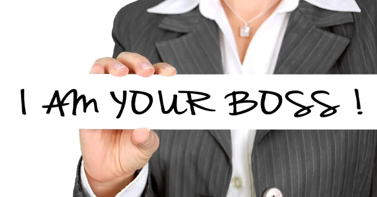 Abstract image of a suited female torso holding up a sign that reads 'I am your boss'.